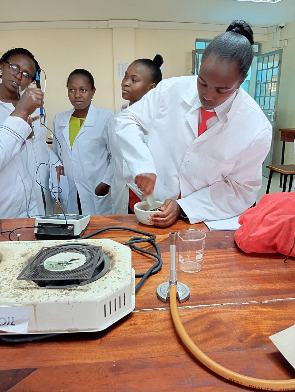Students conducting chemistry experiments at Hiriga Girls' Senior School